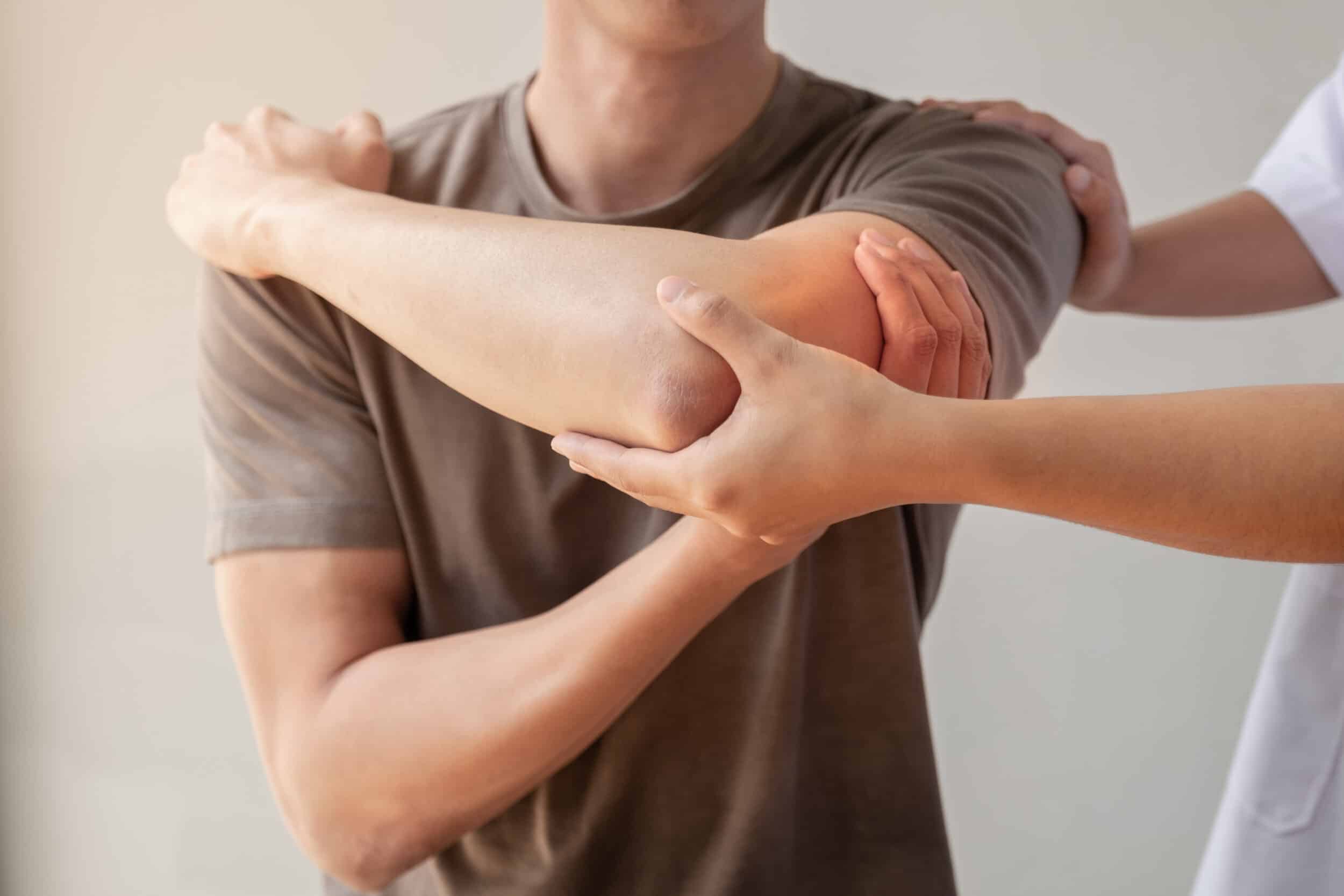 Surgeon examines man's painful elbow