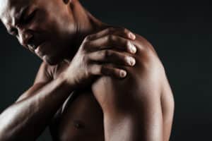 Man with cervical radiculopathy holding his arm
